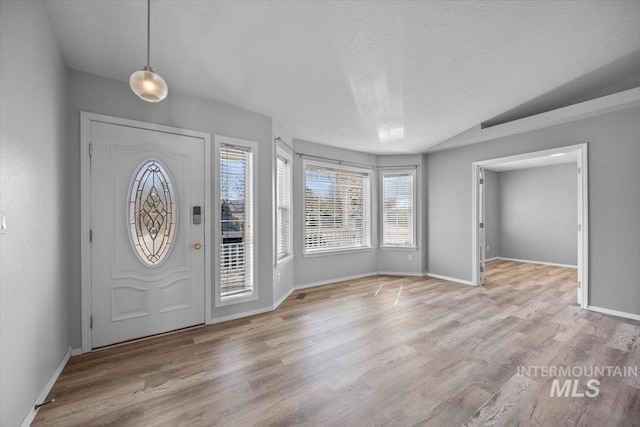 entrance foyer featuring baseboards, wood finished floors, and a textured ceiling