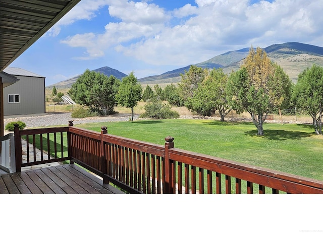 deck with a mountain view and a lawn