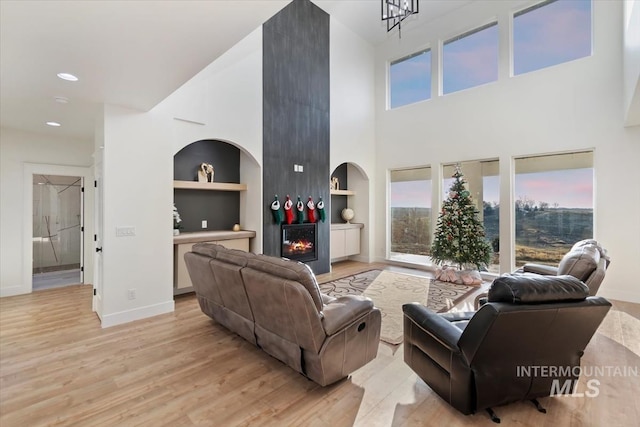 living room featuring light hardwood / wood-style floors, built in features, and a fireplace