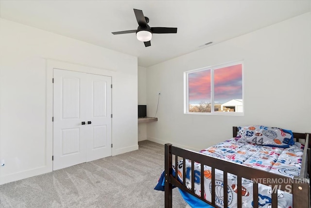 carpeted bedroom featuring a closet and ceiling fan