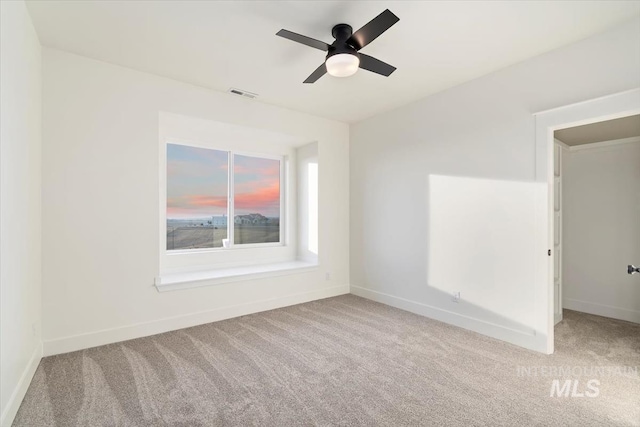 carpeted spare room with ceiling fan