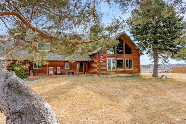 log home featuring log siding, a front lawn, and roof with shingles