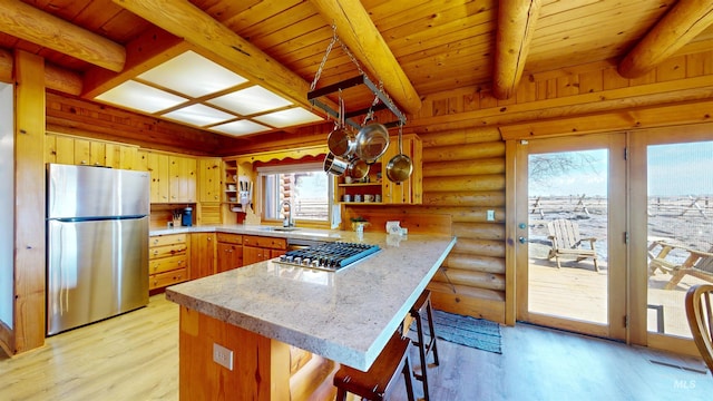 kitchen with beamed ceiling, light wood-type flooring, a peninsula, stainless steel appliances, and open shelves