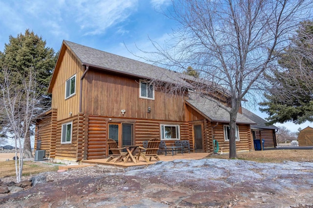 back of property featuring central air condition unit and log siding