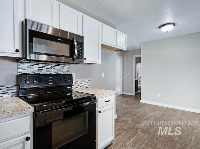 kitchen with white cabinetry, a textured ceiling, light wood-type flooring, electric range, and backsplash