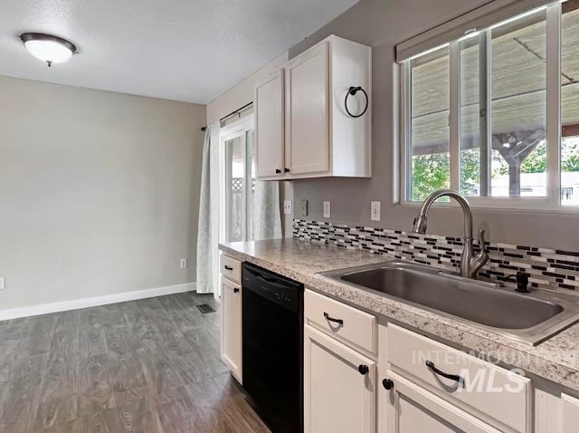 kitchen featuring tasteful backsplash, black dishwasher, dark wood-type flooring, white cabinets, and sink