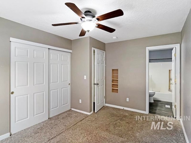 unfurnished bedroom featuring ceiling fan, a closet, wood-type flooring, a textured ceiling, and connected bathroom