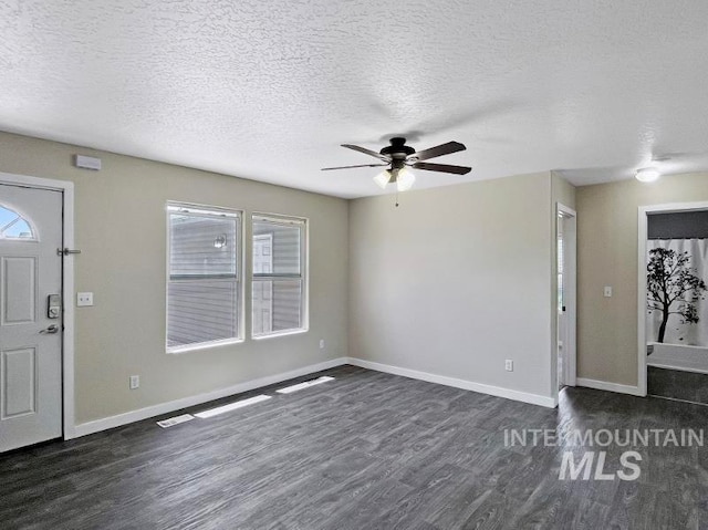 entrance foyer with ceiling fan, dark hardwood / wood-style flooring, and a textured ceiling