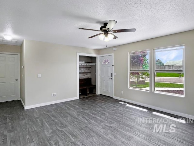 spare room featuring ceiling fan, a textured ceiling, and dark wood-type flooring