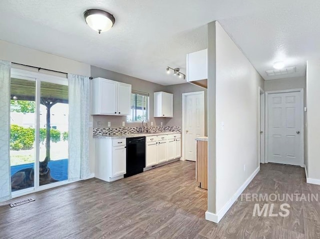 kitchen with dishwasher, hardwood / wood-style floors, white cabinetry, track lighting, and sink