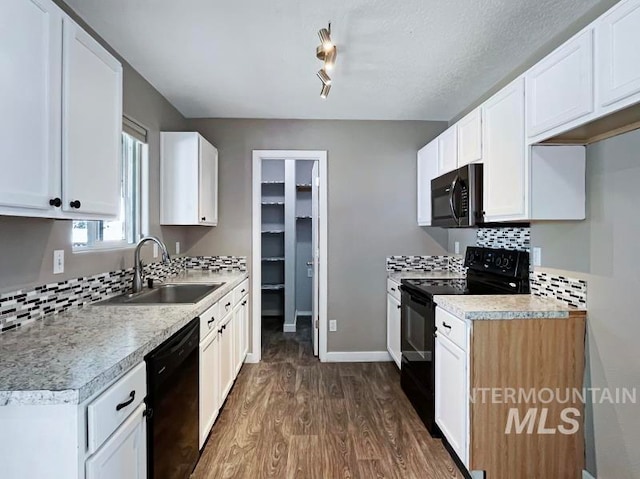 kitchen featuring white cabinetry, sink, black appliances, and dark hardwood / wood-style floors