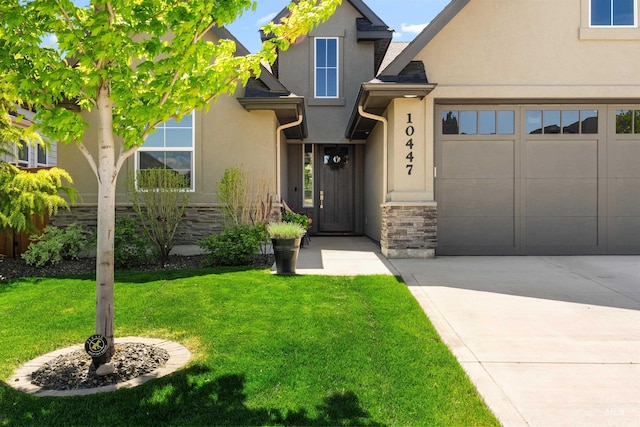 view of front of property featuring a garage, a front lawn, stone siding, stucco siding, and driveway