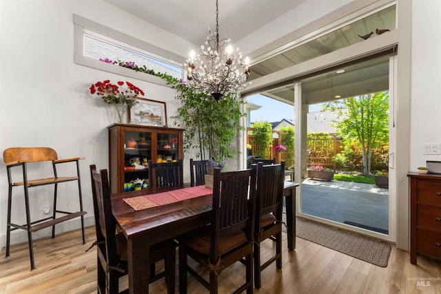 dining space with light wood-style flooring and a chandelier