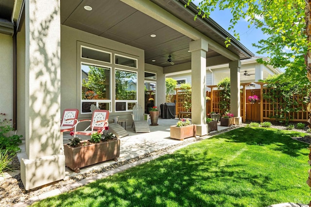 view of patio featuring fence and a ceiling fan