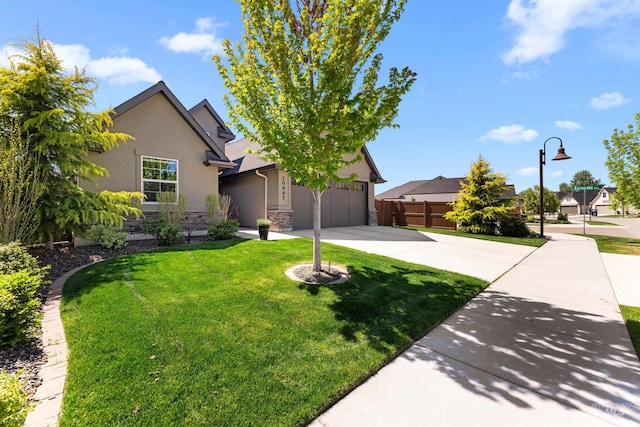 view of front of house with a front yard, fence, concrete driveway, stone siding, and stucco siding
