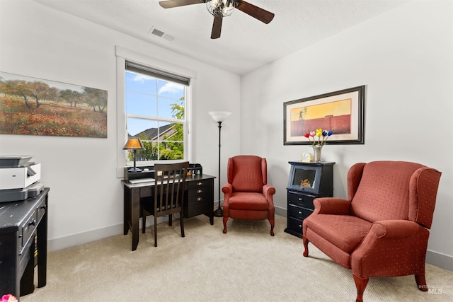 living area with baseboards, light carpet, a ceiling fan, and visible vents