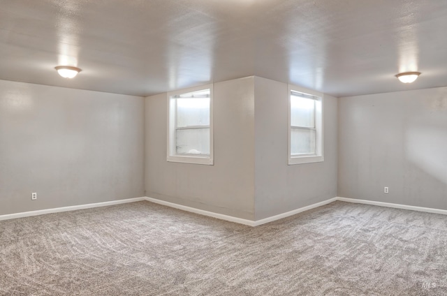 carpeted spare room featuring baseboards