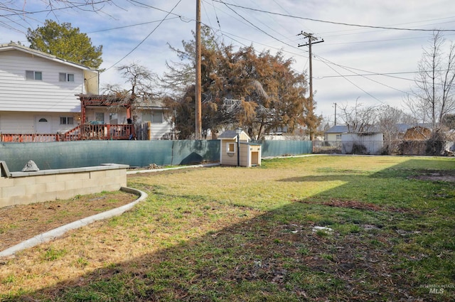 view of yard featuring a storage shed, an outbuilding, and a fenced backyard