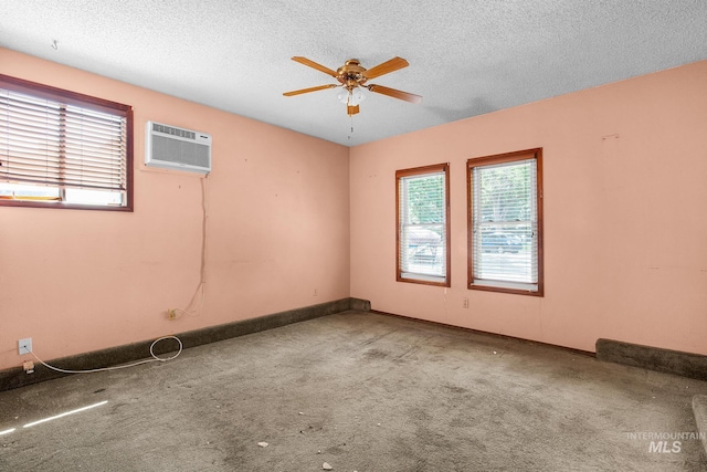 carpeted spare room featuring a textured ceiling, a wall mounted AC, and ceiling fan