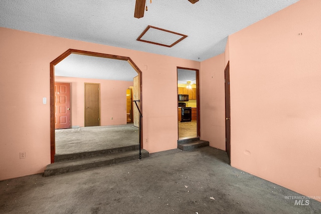 unfurnished room with ceiling fan and a textured ceiling