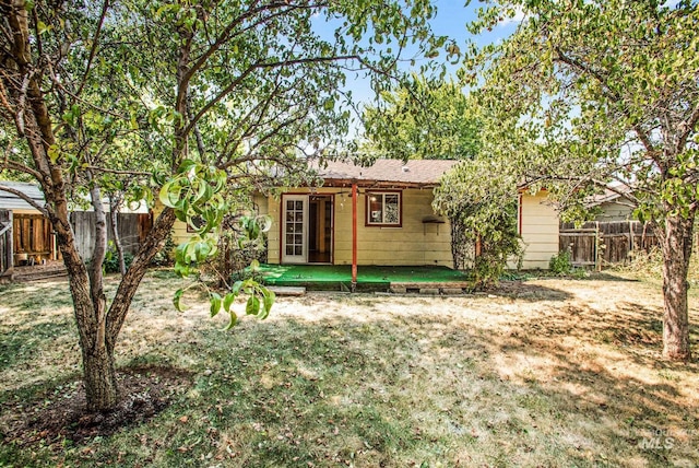 rear view of property with a yard