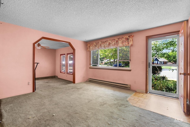 carpeted spare room with a textured ceiling, ceiling fan, and baseboard heating