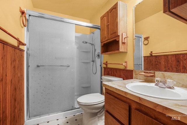 bathroom featuring an enclosed shower, vanity, and toilet