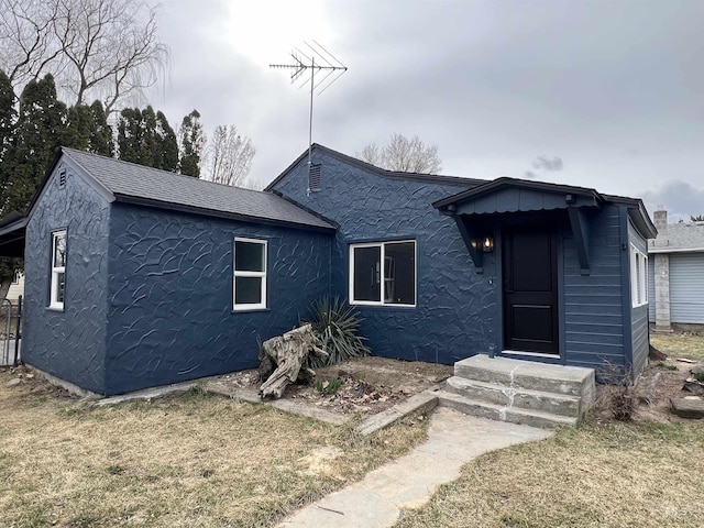 view of front of property featuring stucco siding and a shingled roof