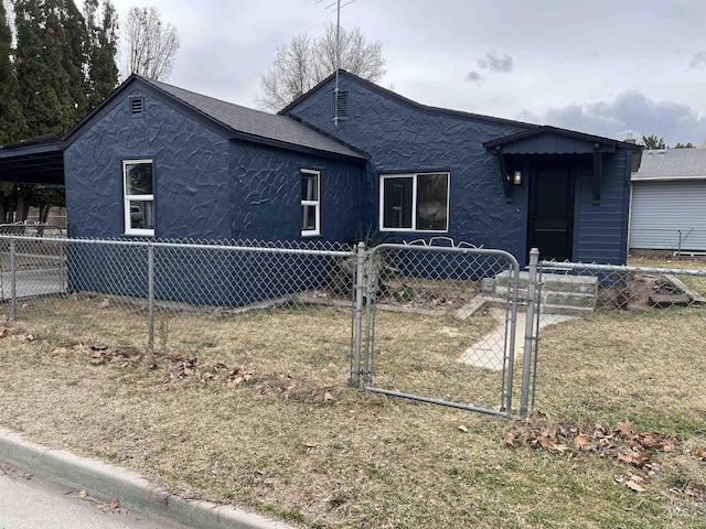 view of front facade with a shingled roof, a gate, fence private yard, and stucco siding