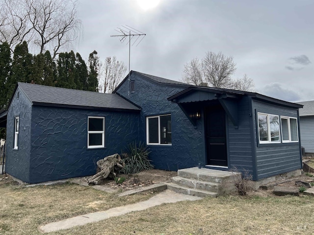 view of front of property featuring roof with shingles and stucco siding