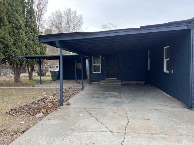 view of vehicle parking featuring entry steps, an attached carport, and driveway