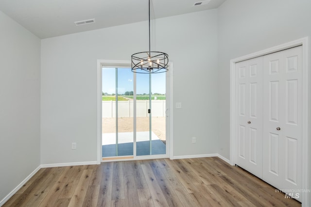 interior space with a notable chandelier, light hardwood / wood-style flooring, and vaulted ceiling