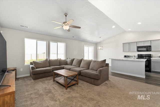 living room with a textured ceiling, vaulted ceiling, and ceiling fan