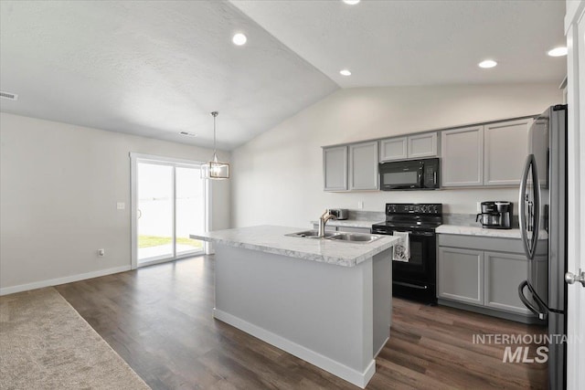 kitchen featuring dark hardwood / wood-style floors, an island with sink, pendant lighting, gray cabinets, and black appliances