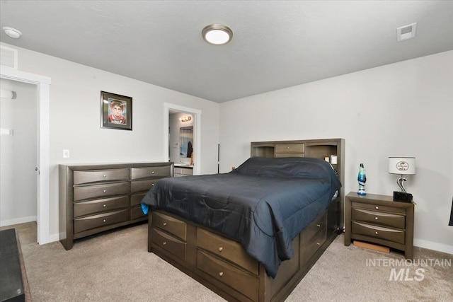 bedroom featuring ensuite bath and light colored carpet