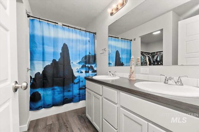 bathroom with a shower with curtain, vanity, wood-type flooring, and a textured ceiling