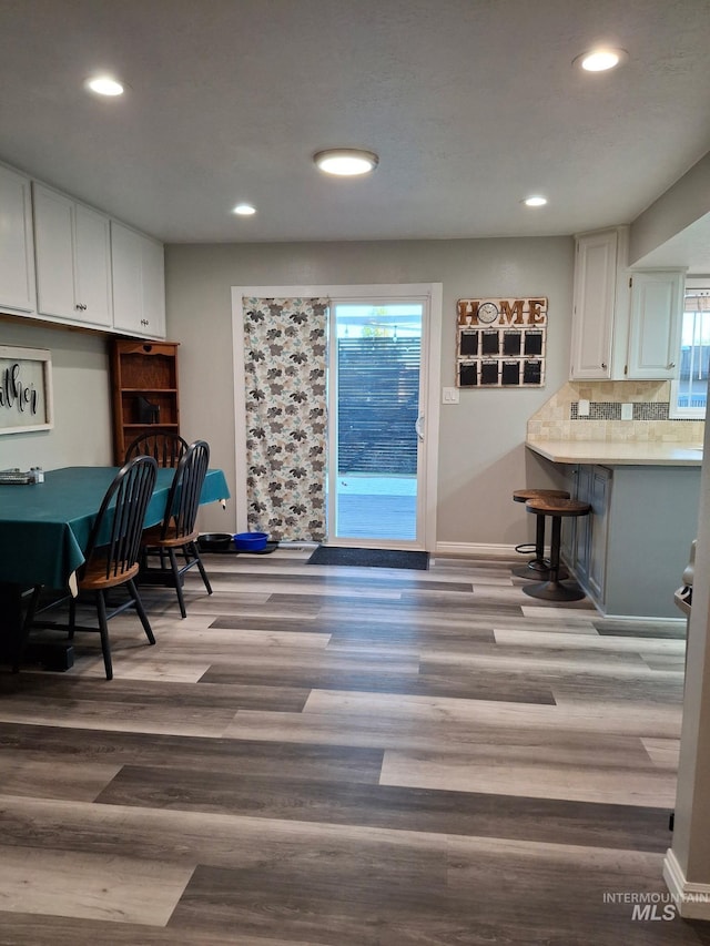 dining room with recessed lighting, wood finished floors, and baseboards