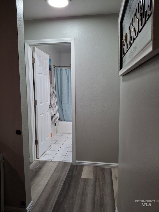 hall with wood finished floors and baseboards