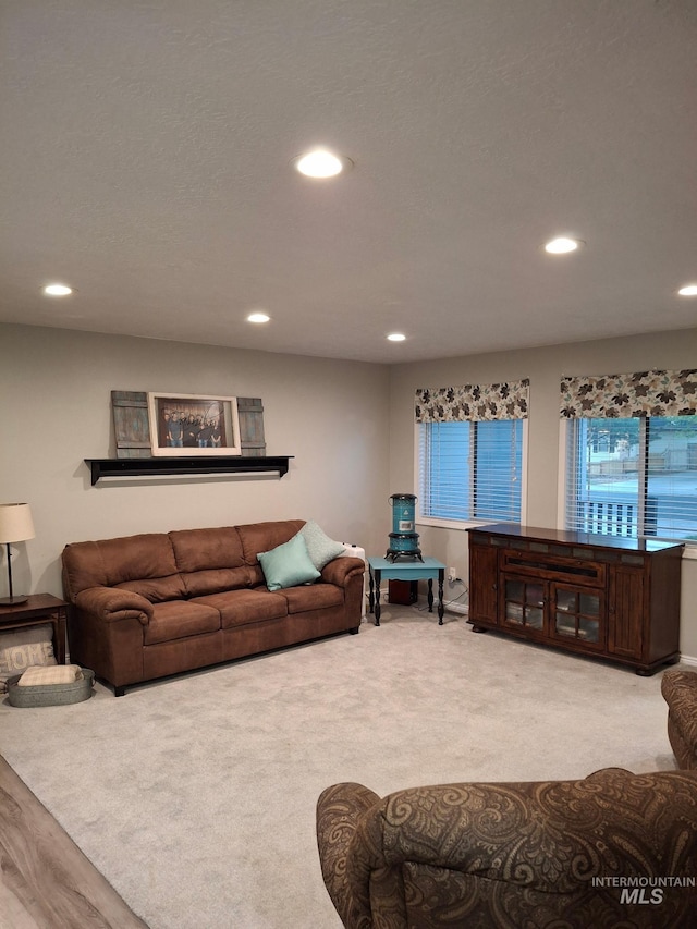 living area with recessed lighting and light carpet