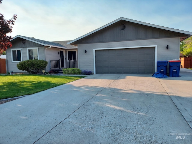 single story home with a front yard, concrete driveway, and an attached garage