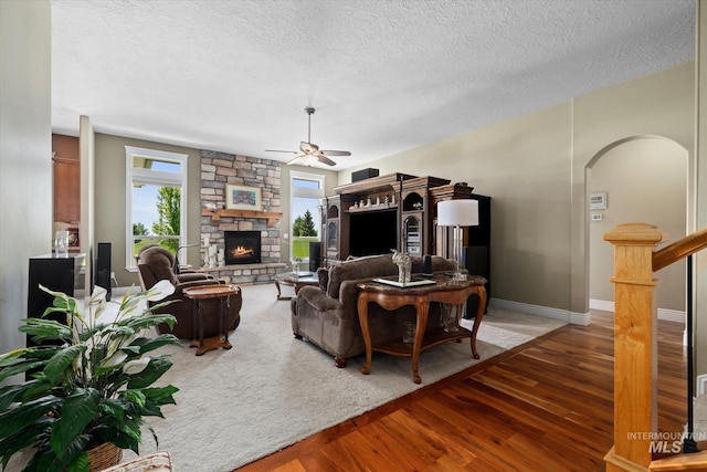 8585 W Rioja St, Star, ID 83669 - living area with wood-type flooring, ceiling fan, a fireplace, a textured ceiling, and baseboards