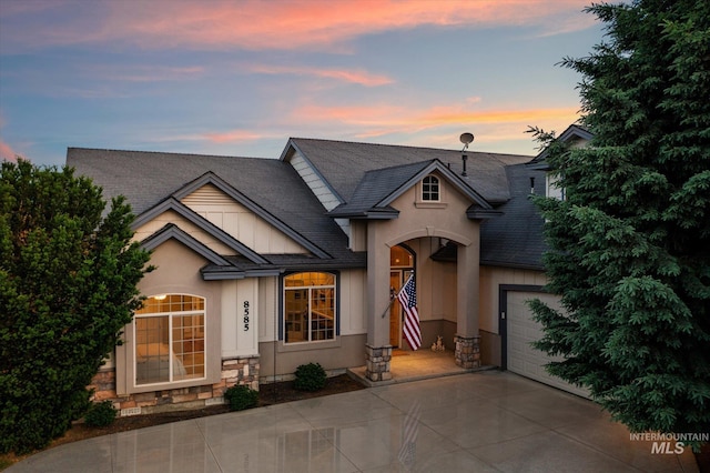 8585 W Rioja St, Star, ID 83669 - view of front of house featuring stucco siding, stone siding, concrete driveway, roof with shingles, and an attached garage