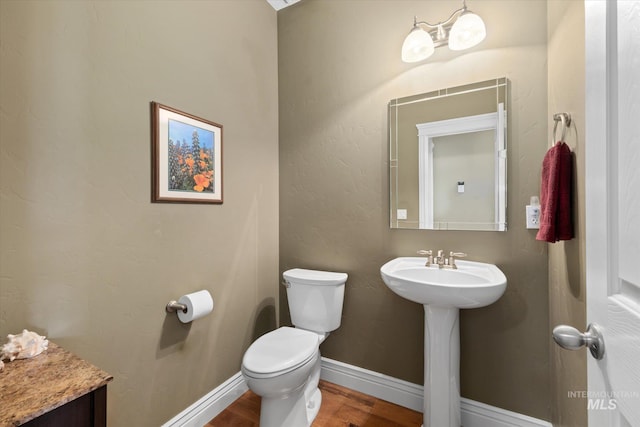 8585 W Rioja St, Star, ID 83669 - half bathroom with toilet, wood finished floors, a sink, and baseboards