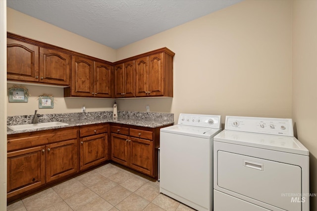 8585 W Rioja St, Star, ID 83669 - laundry area with independent washer and dryer, cabinet space, light tile patterned floors, and a textured ceiling