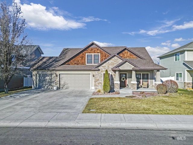 craftsman inspired home with covered porch, a front lawn, and a garage