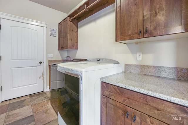 washroom featuring sink, separate washer and dryer, and cabinets