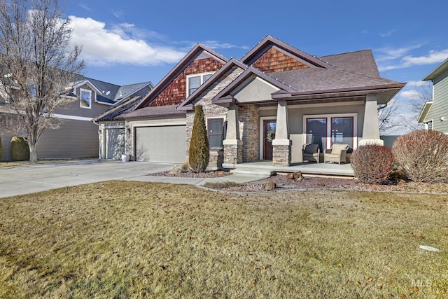 view of front of house with a garage, covered porch, and a front lawn