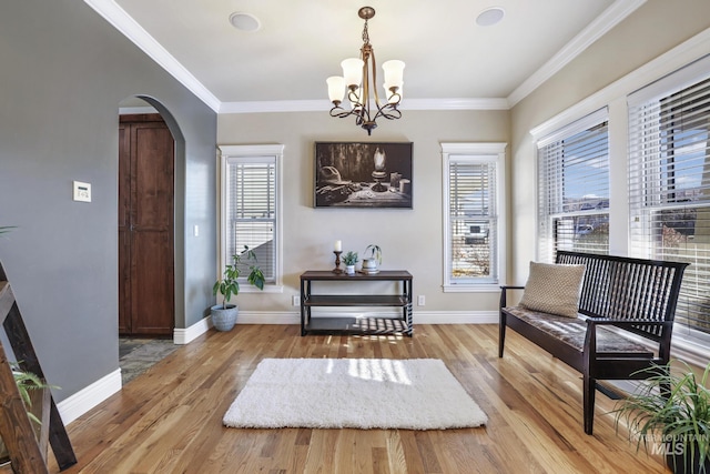 sitting room featuring an inviting chandelier, ornamental molding, light hardwood / wood-style flooring, and plenty of natural light