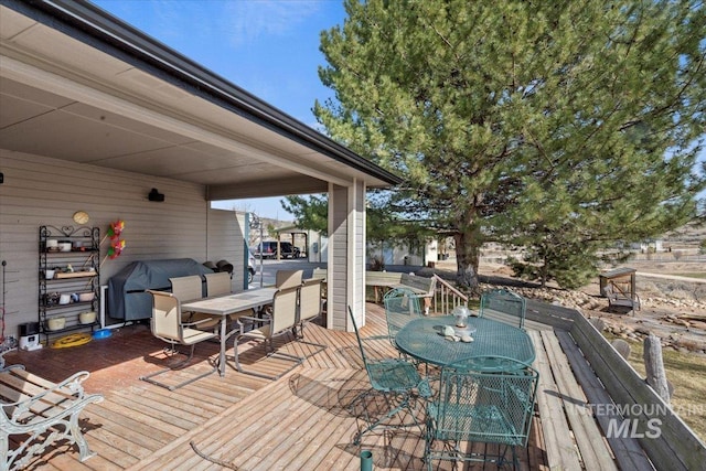 deck with outdoor dining area and grilling area