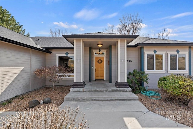 entrance to property with a shingled roof